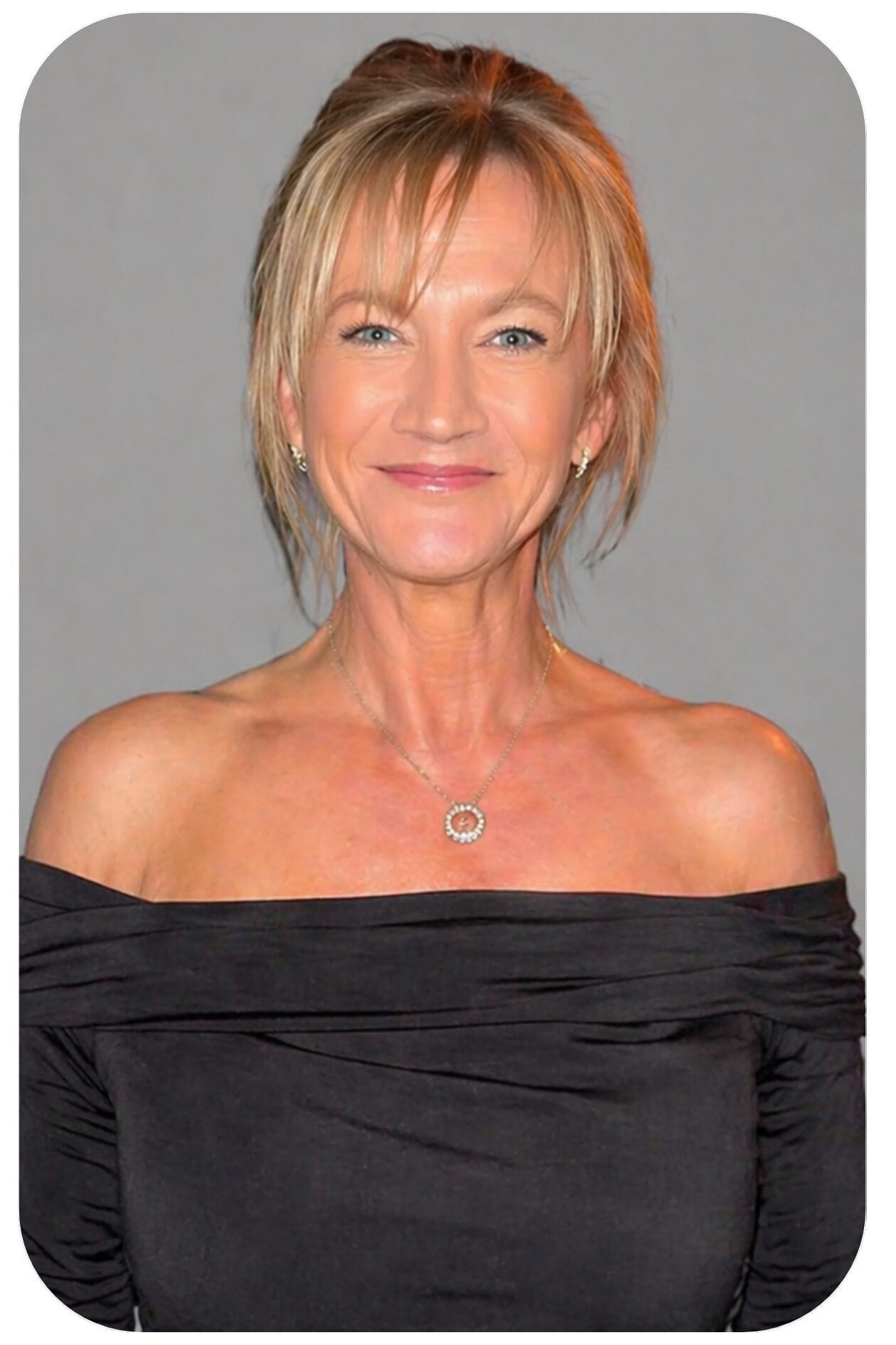 Smiling blonde woman in black off-shoulder dress